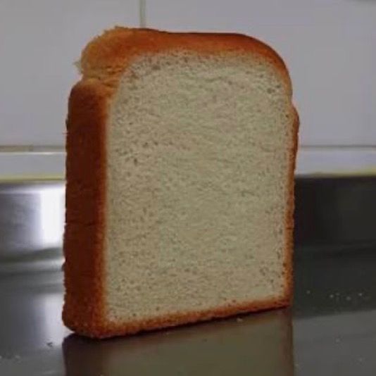A single slice of white bread standing upright